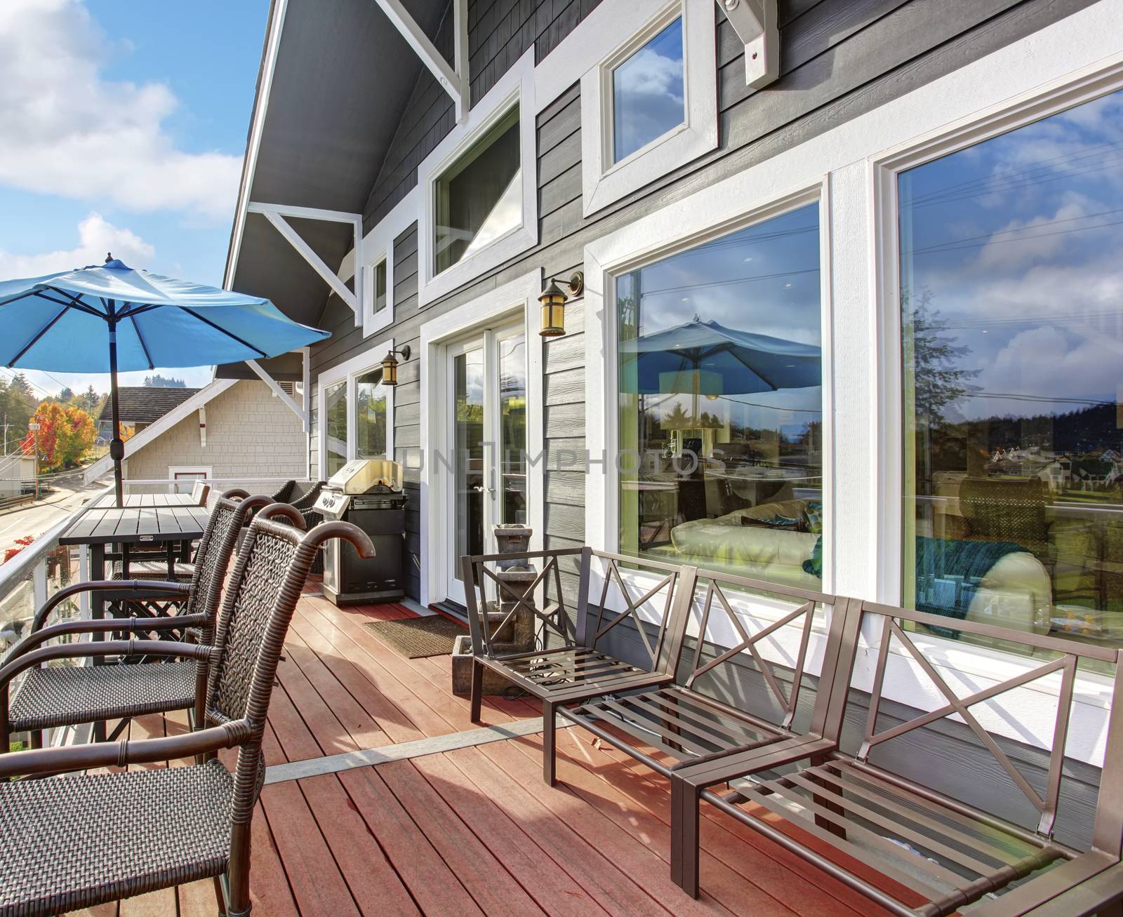 Northwest traditional wooden deck with water veiw. windows and chairs.