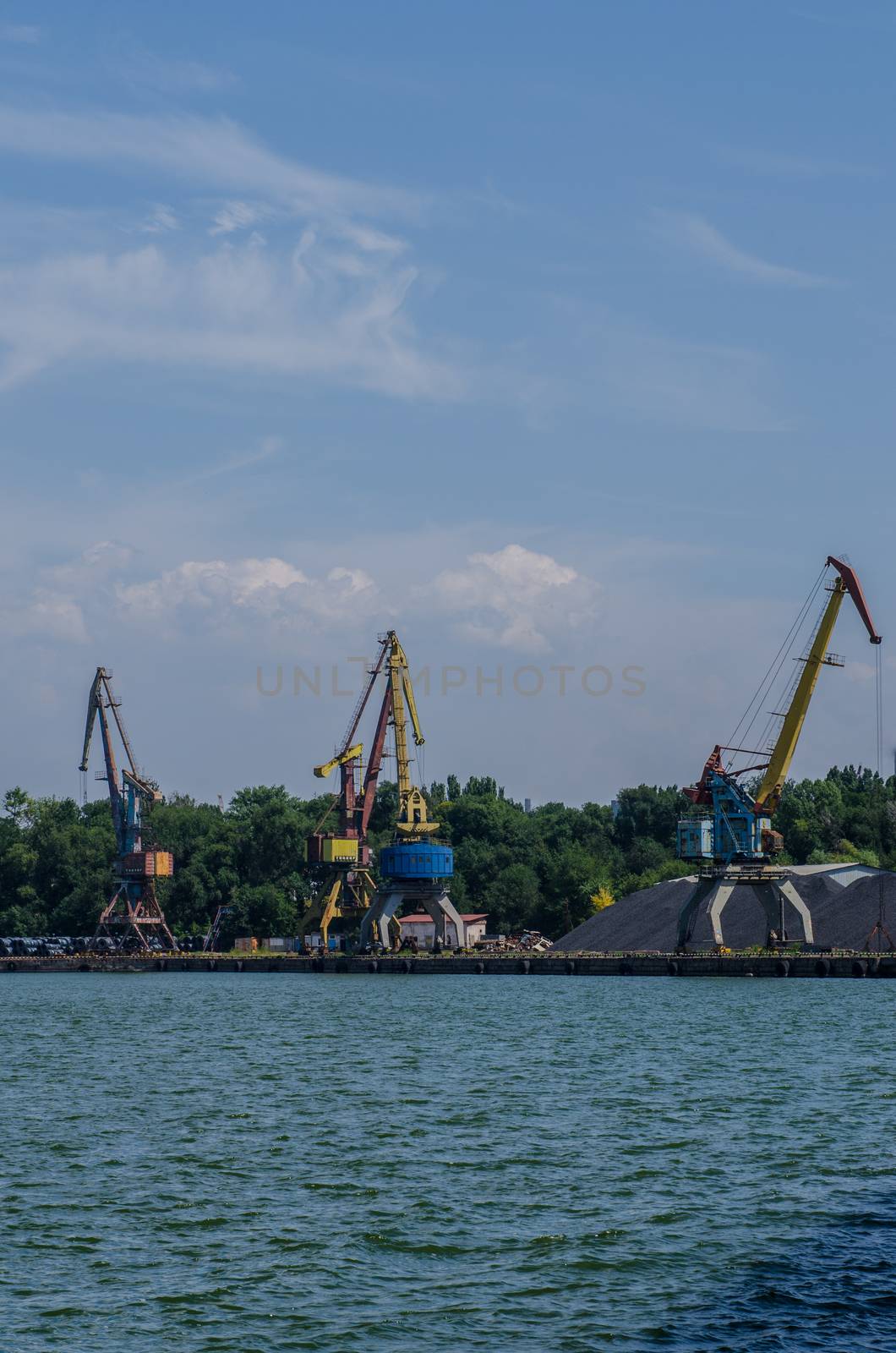 cargo port with cargo cranes on a blue sky background