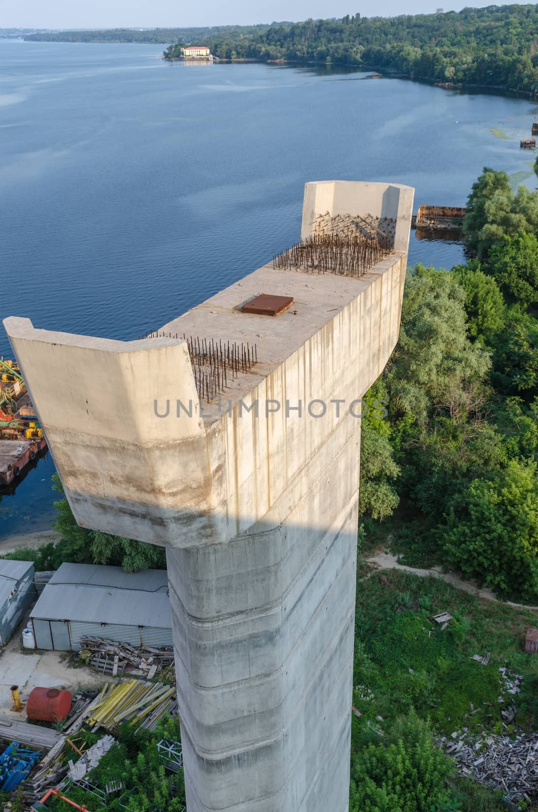 the construction of a bridge across the river with the supports, structural elements, cranes