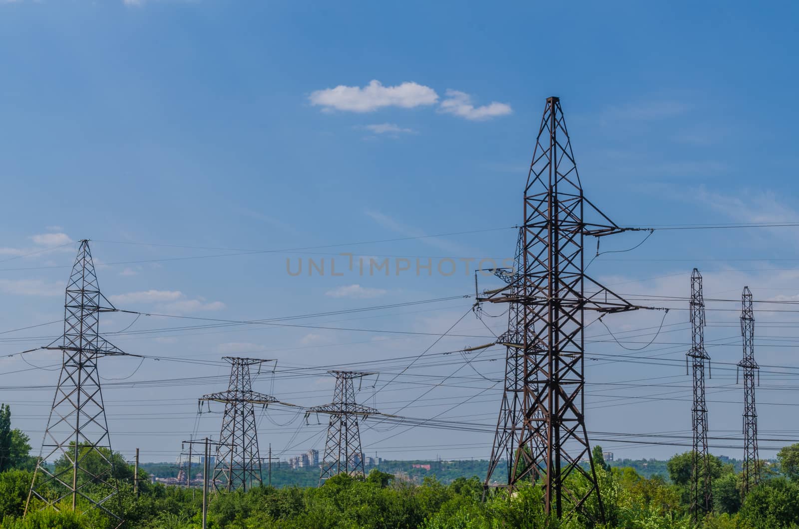 supports of high-voltage power lines against the blue sky