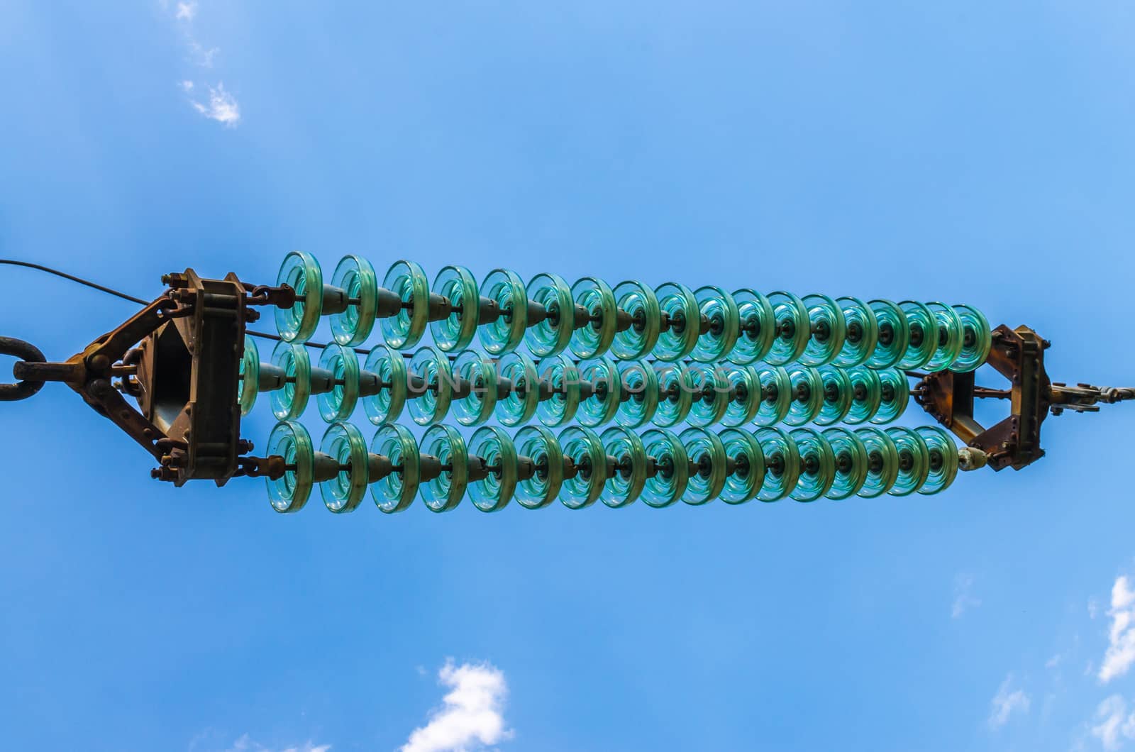 supports of high-voltage power lines against the blue sky