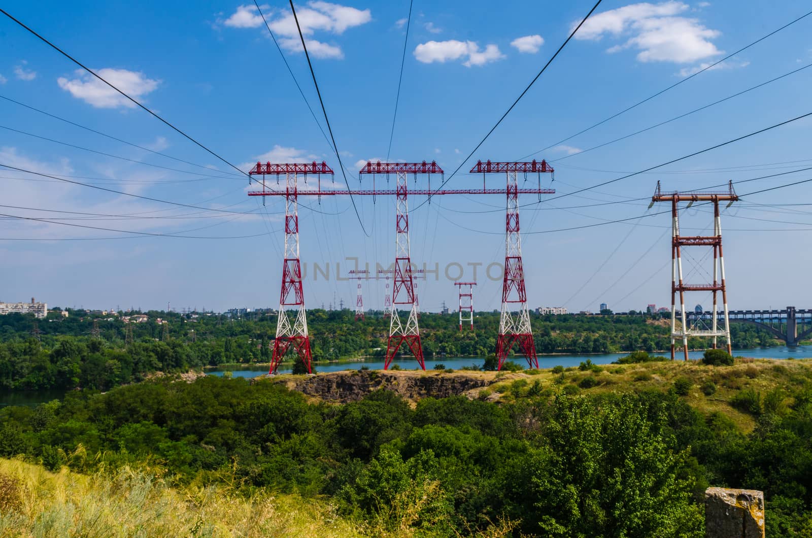 supports of high-voltage power lines against the blue sky