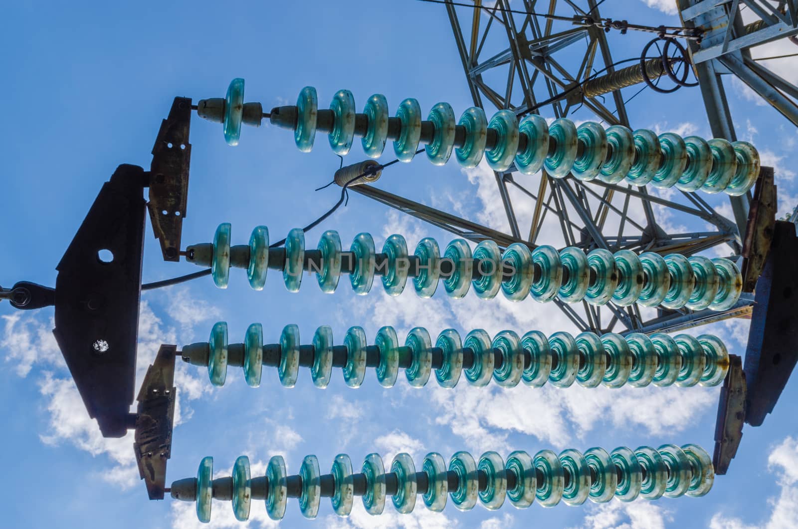 supports of high-voltage power lines against the blue sky