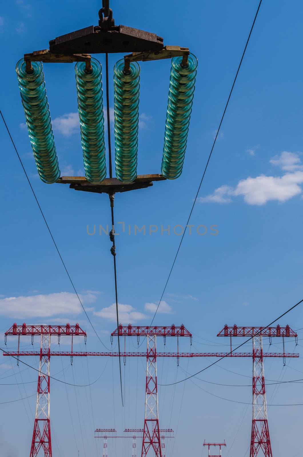 supports of high-voltage power lines against the blue sky