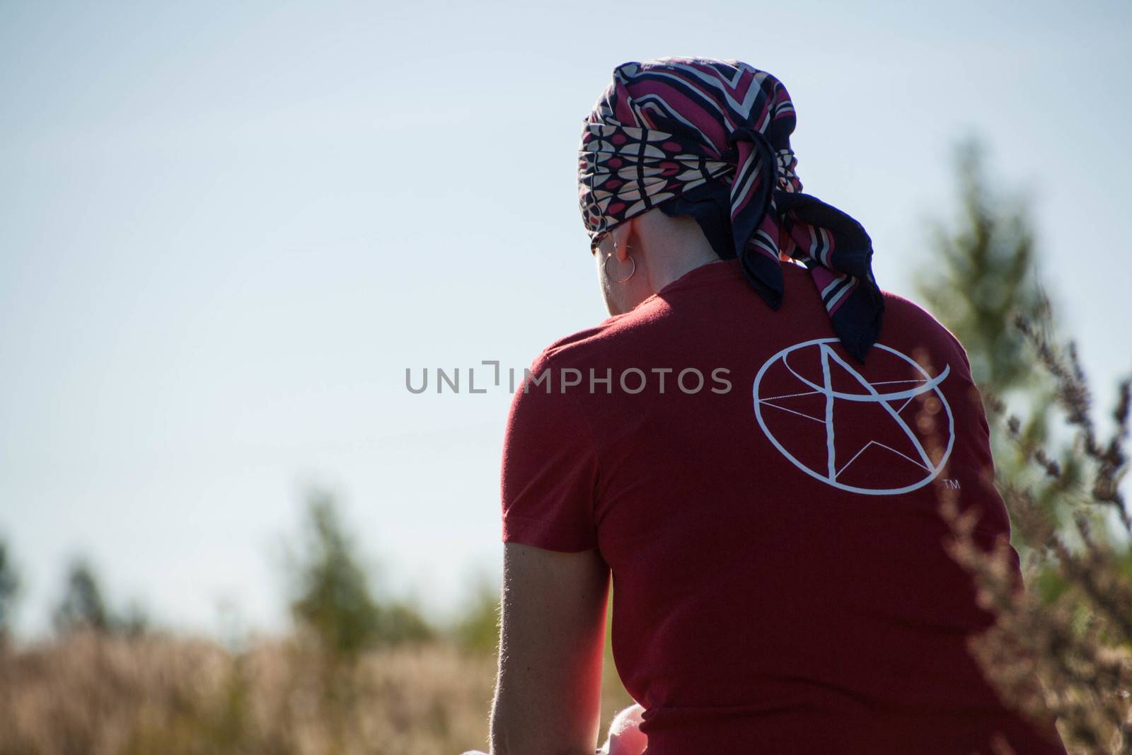  young woman sits  a field in headscarf by alexx60