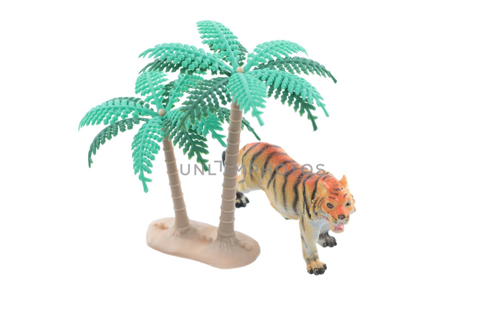 A small toy tiger with trees isolated on a white background.