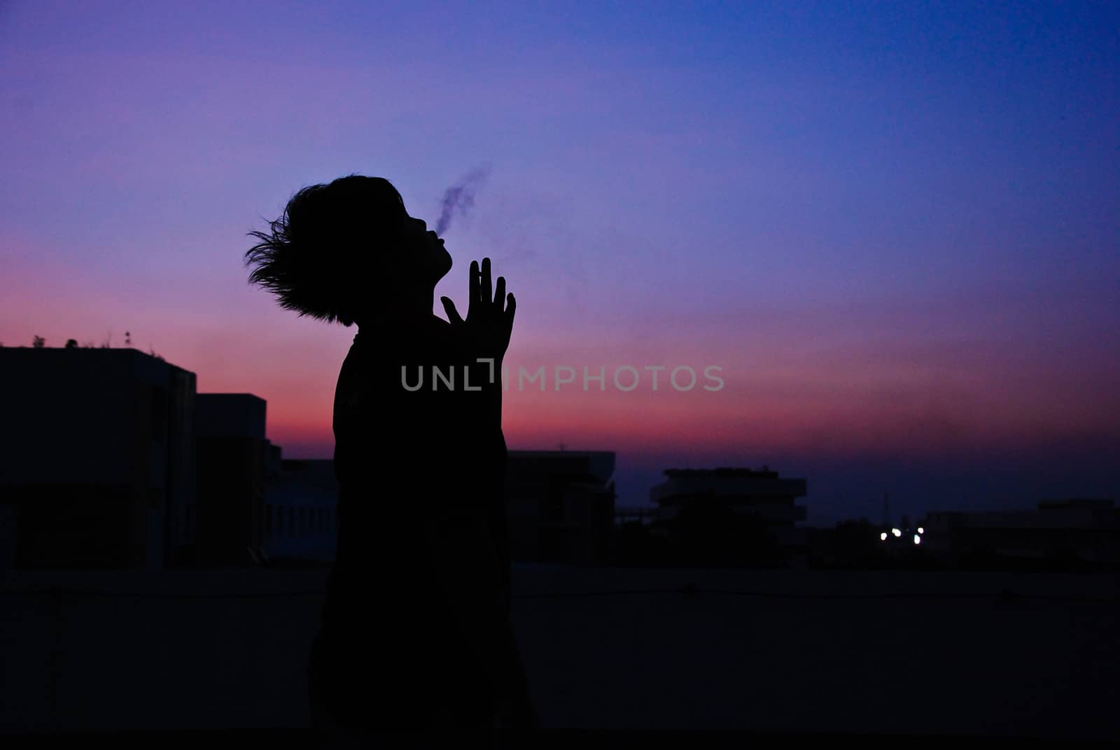 silhouette of man smoke cigarette on top of building evening sunset blue sky so alone but art beautiful