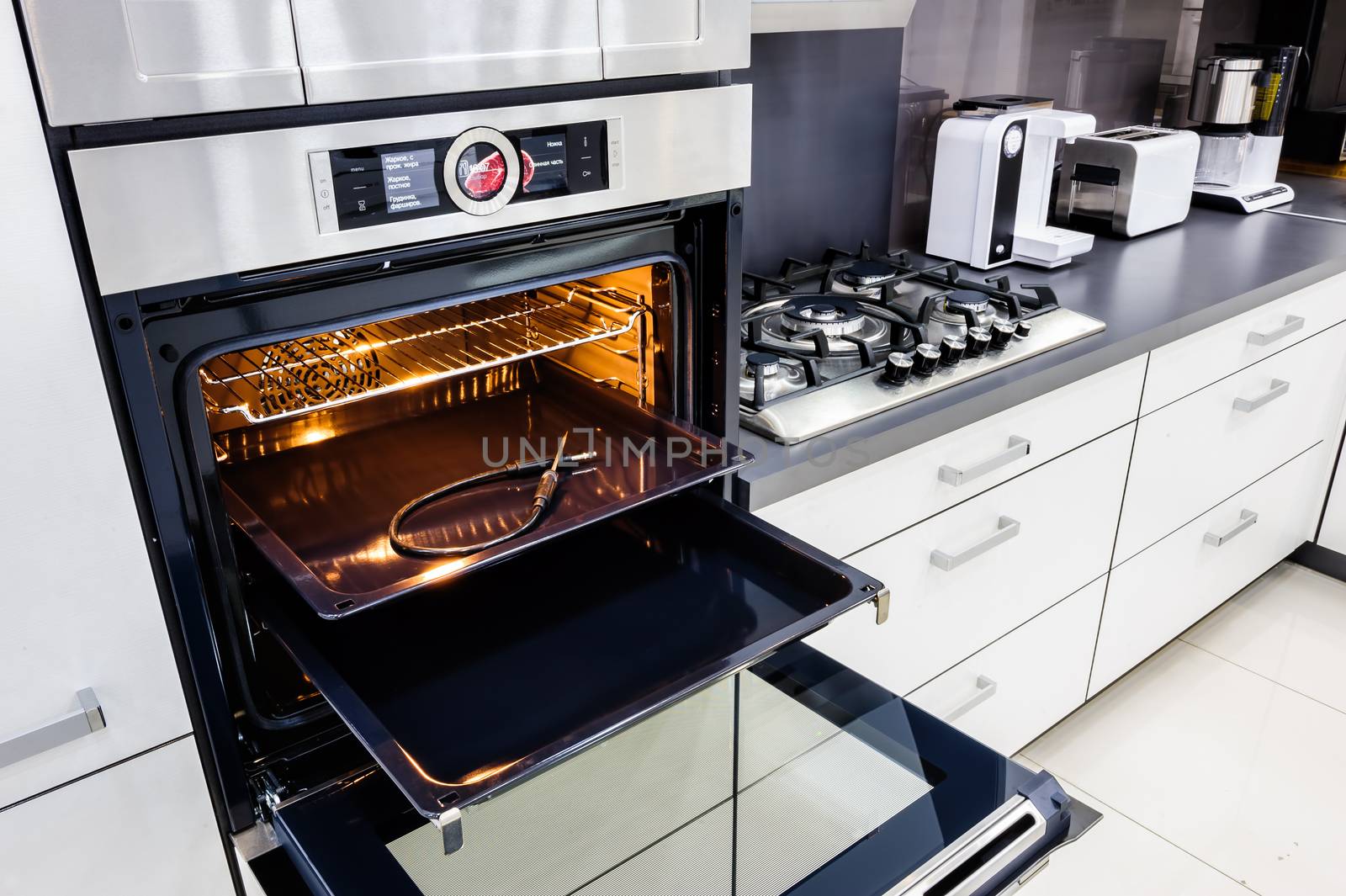 Modern luxury hi-tek black and white kitchen, clean interior design, focu at oven with open door