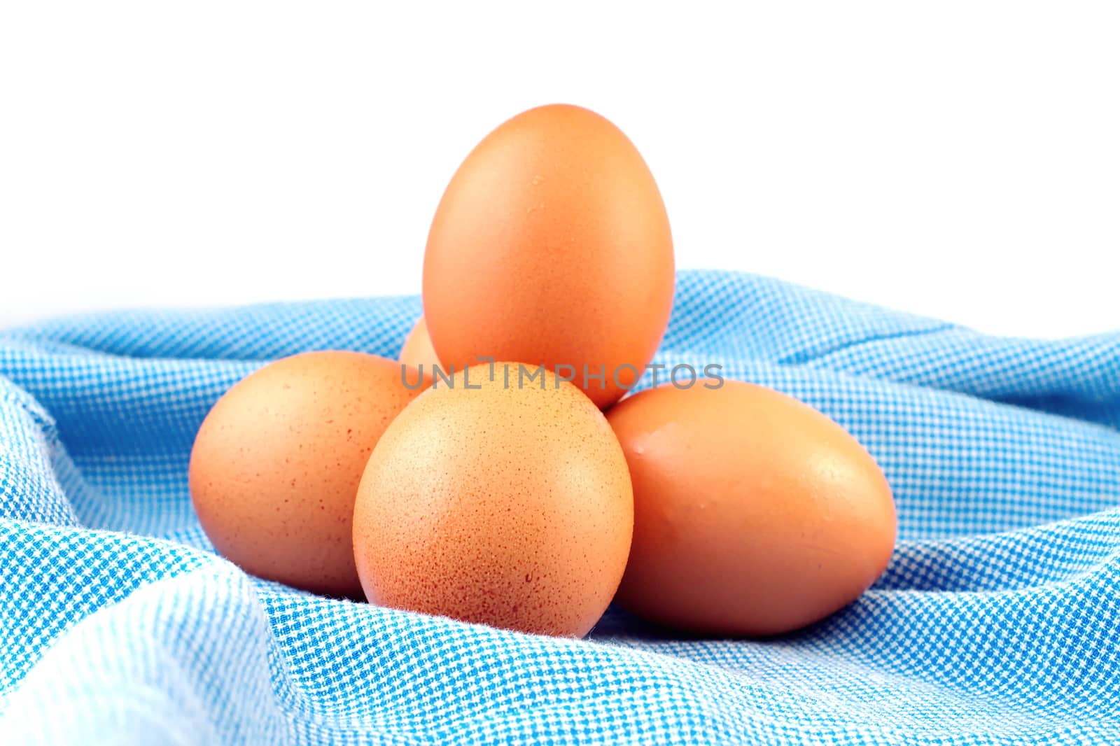 Eggs on blue cloth, select focus on front egg