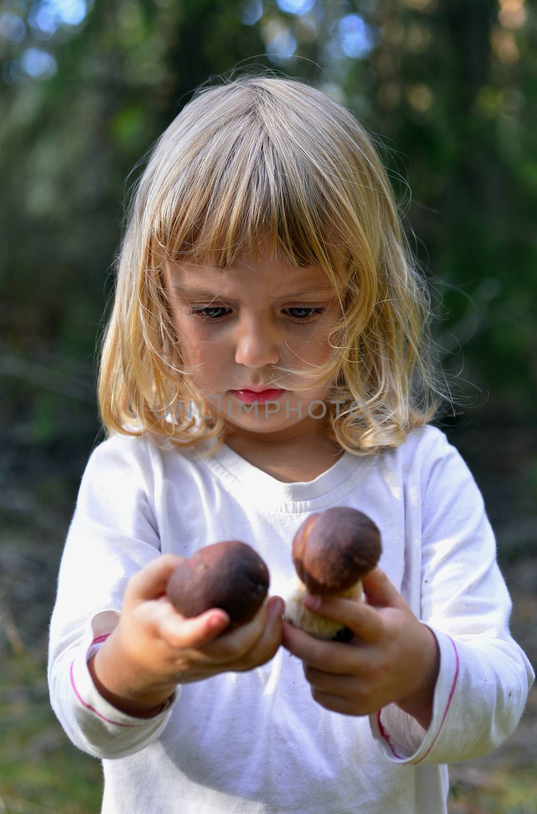 Little girl with two mashrooms in the nahds