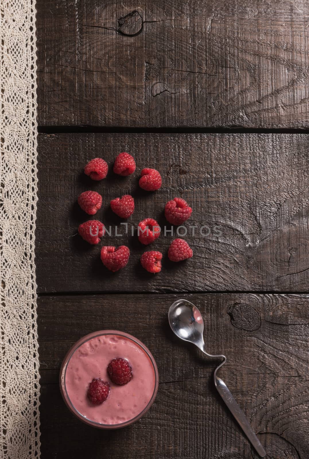 raspberry - banana smoothie on korichnevom the background of natural wood, lace