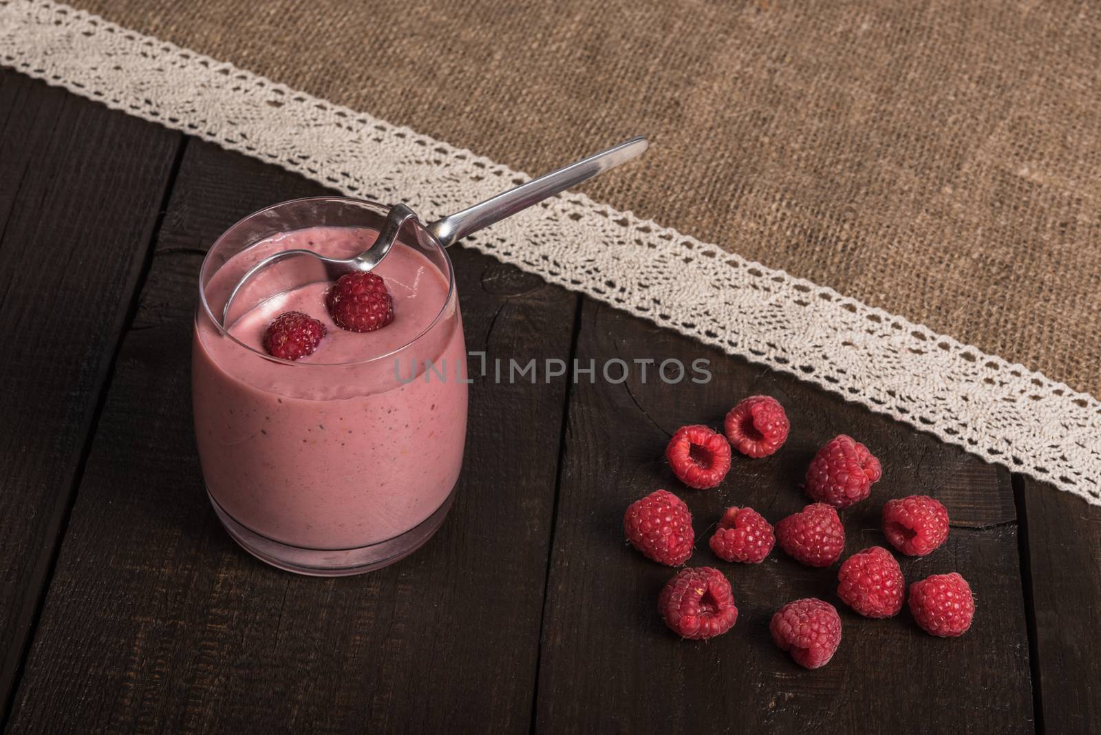 raspberry - banana smoothie on korichnevom the background of natural wood, lace