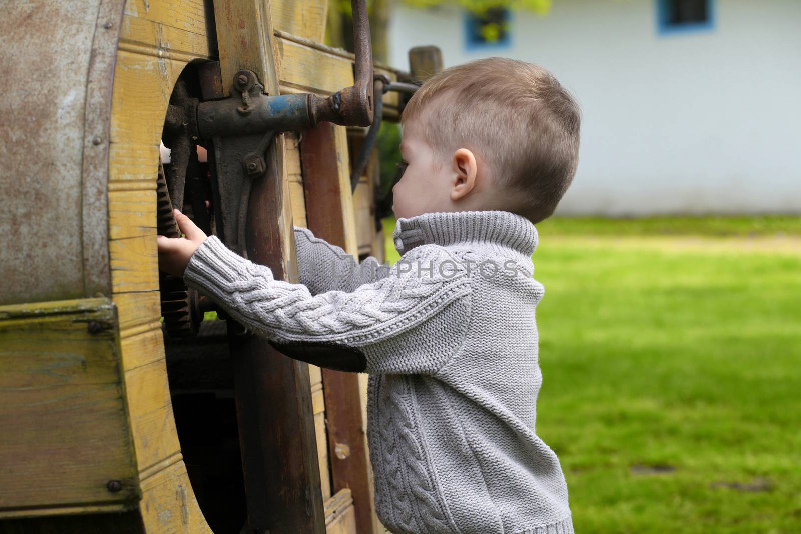 2 years old curious Baby boy managing with old agricultural Machinery