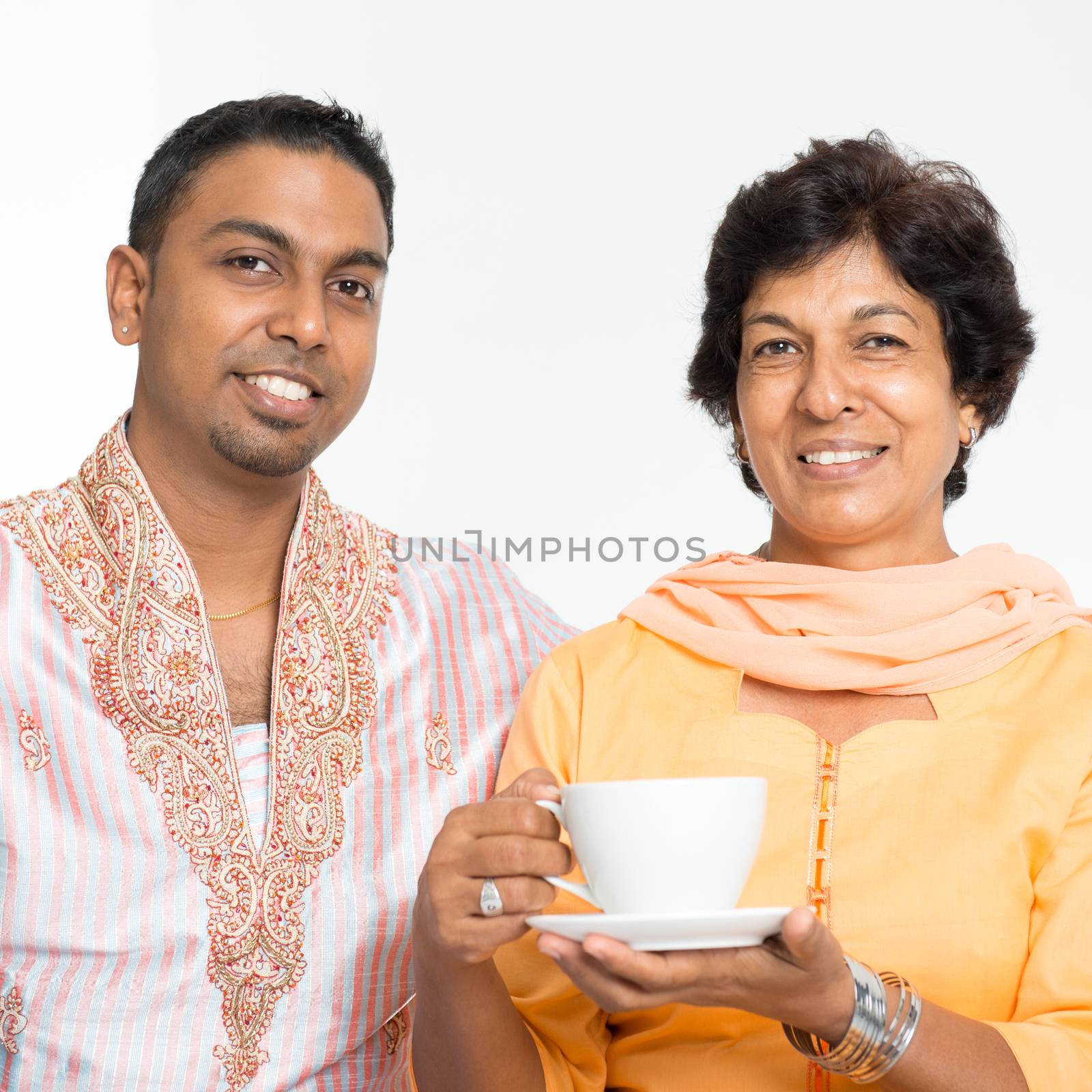 Portrait of happy Indian family at home. Mature 50s Indian mother and 30s grown son.