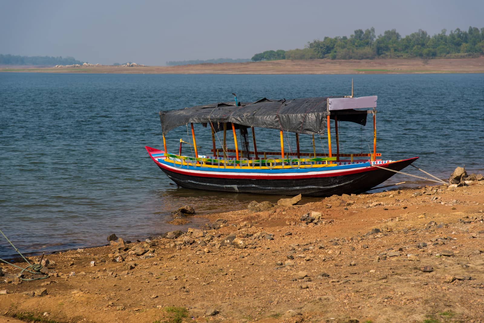 Indian colorful country boat tied at a river bank in Mukutmanipur.