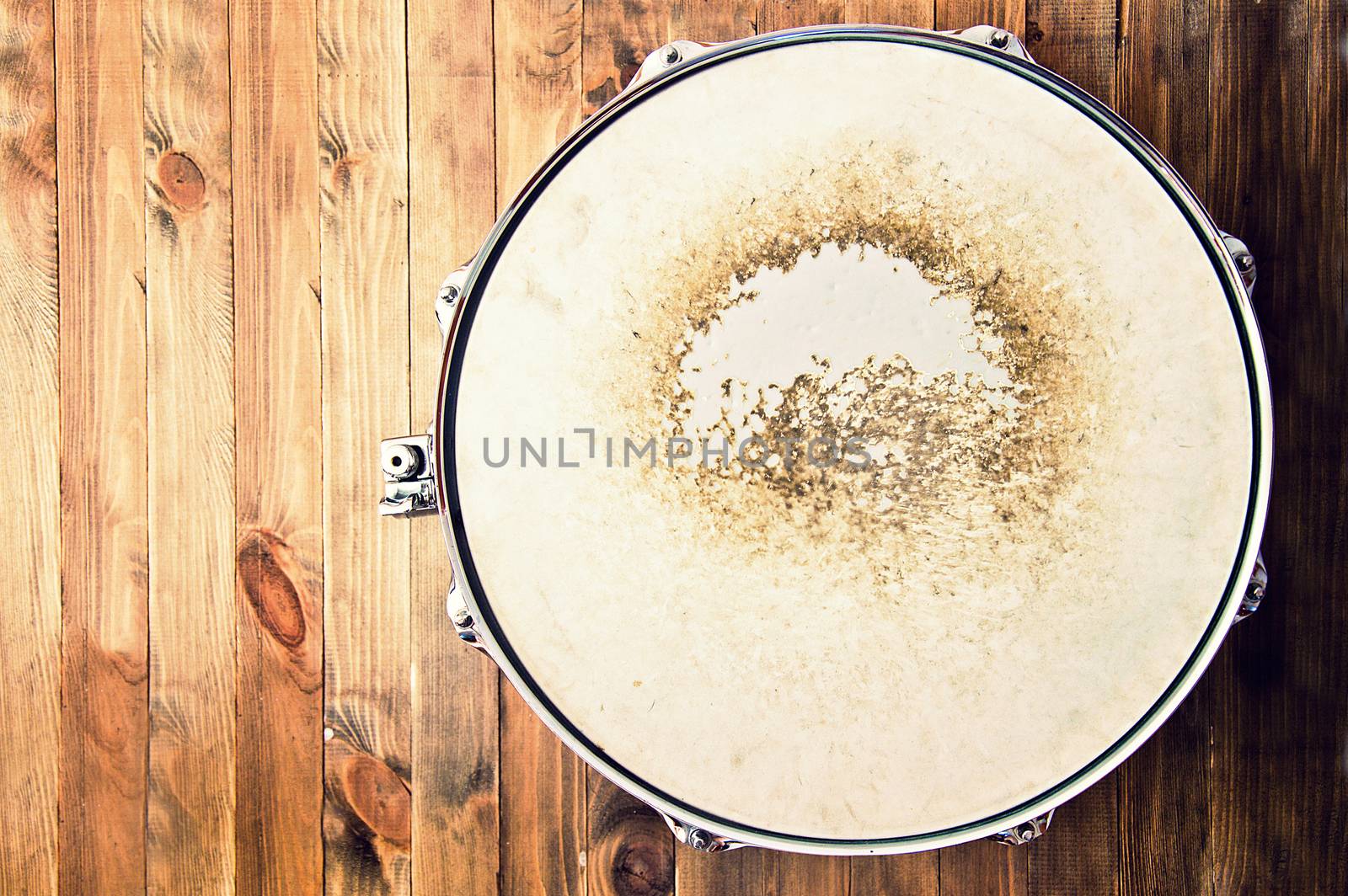 Drums conceptual image. Picture of snare drum lying on wooden background. Retro vintage instagram picture.