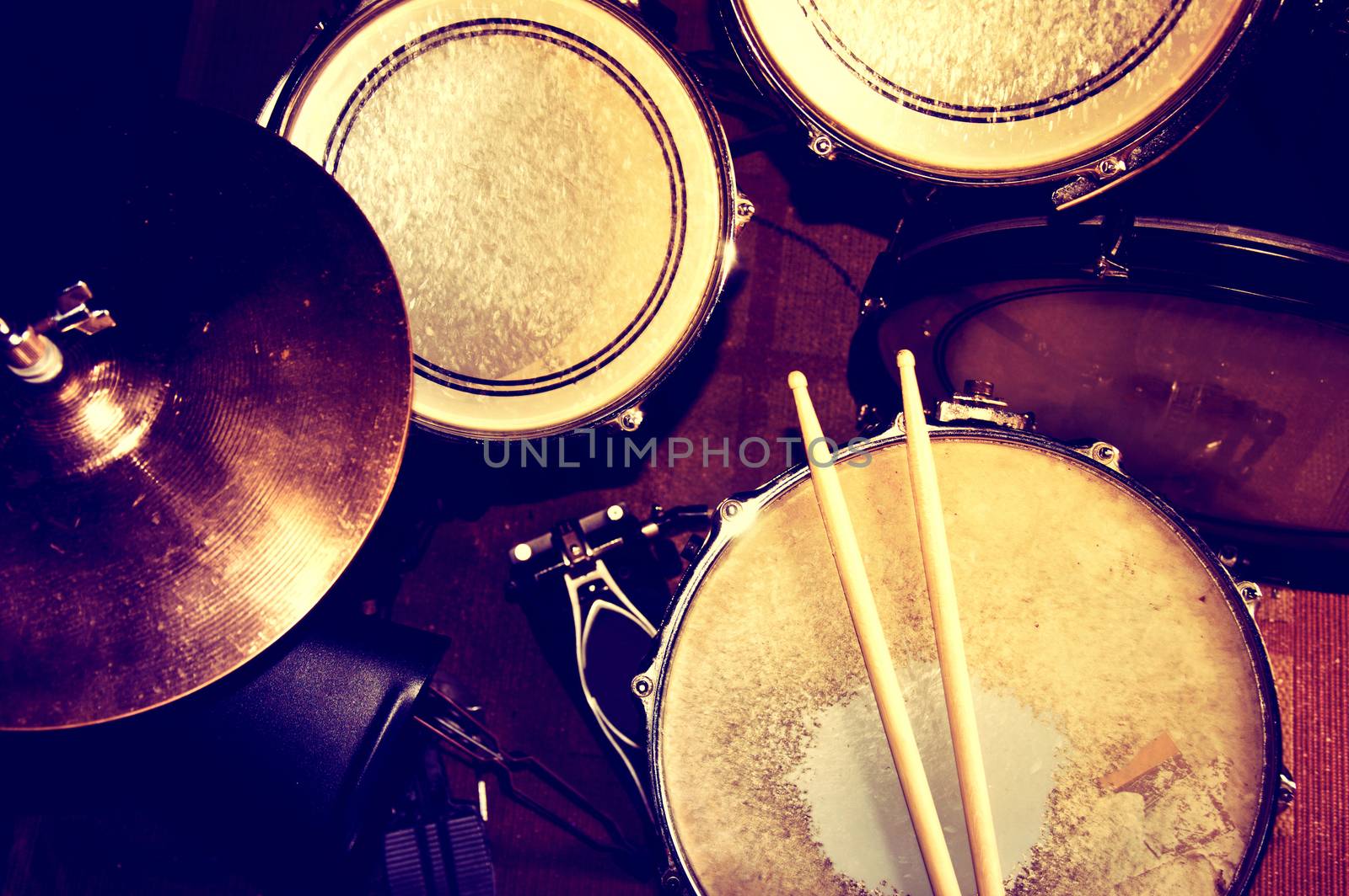 Drums conceptual image. Picture of drums and drumsticks lying on snare drum. Retro vintage instagram picture.