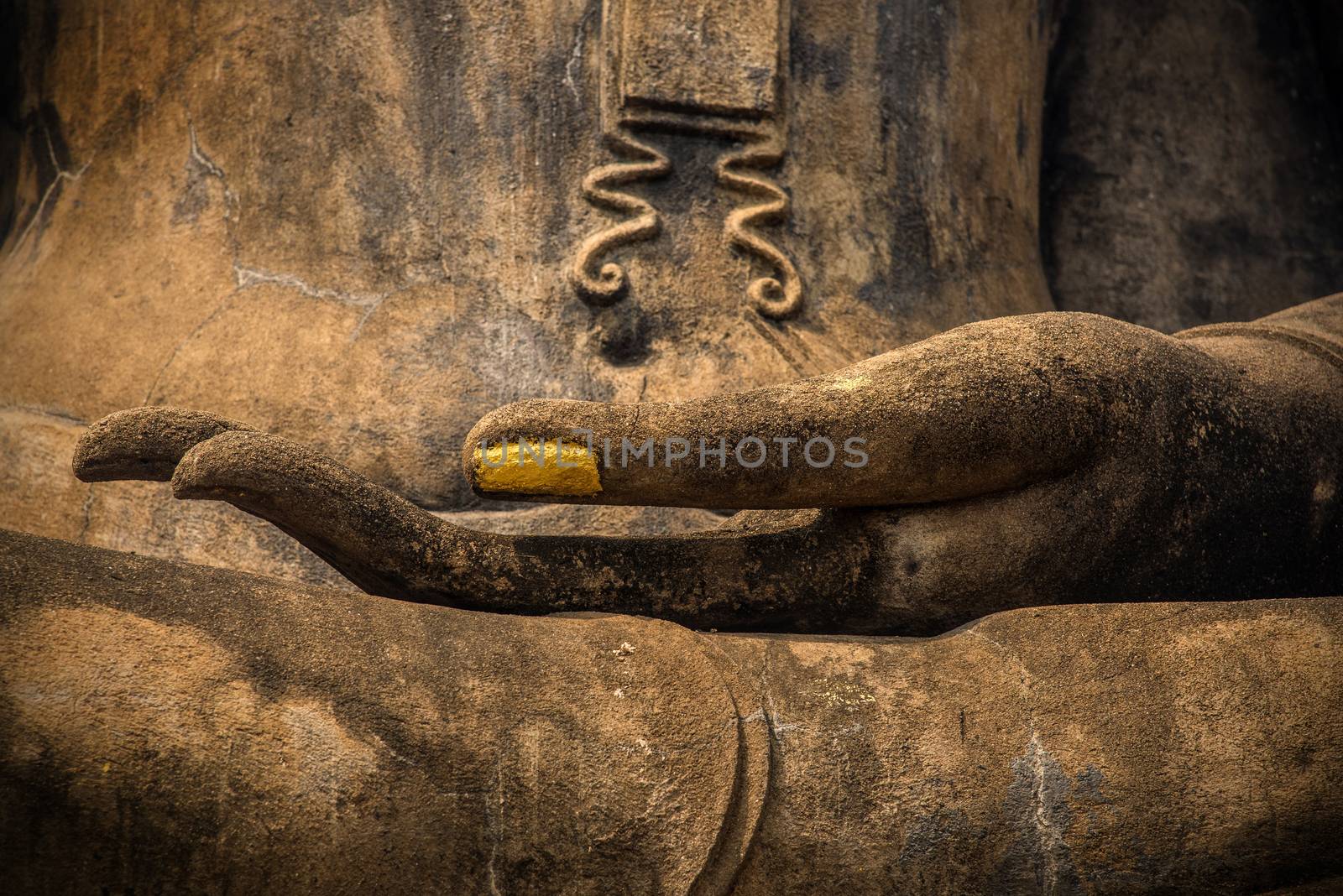Closeup of the hand of Lord Buddha with gold leaf applied on finger nail.