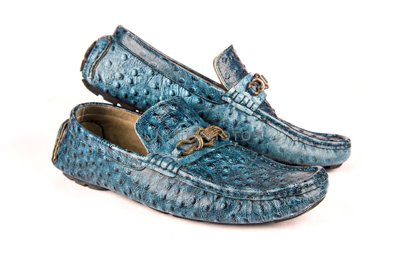 Stylish pair of alligator skin blue leather moccasins over white background