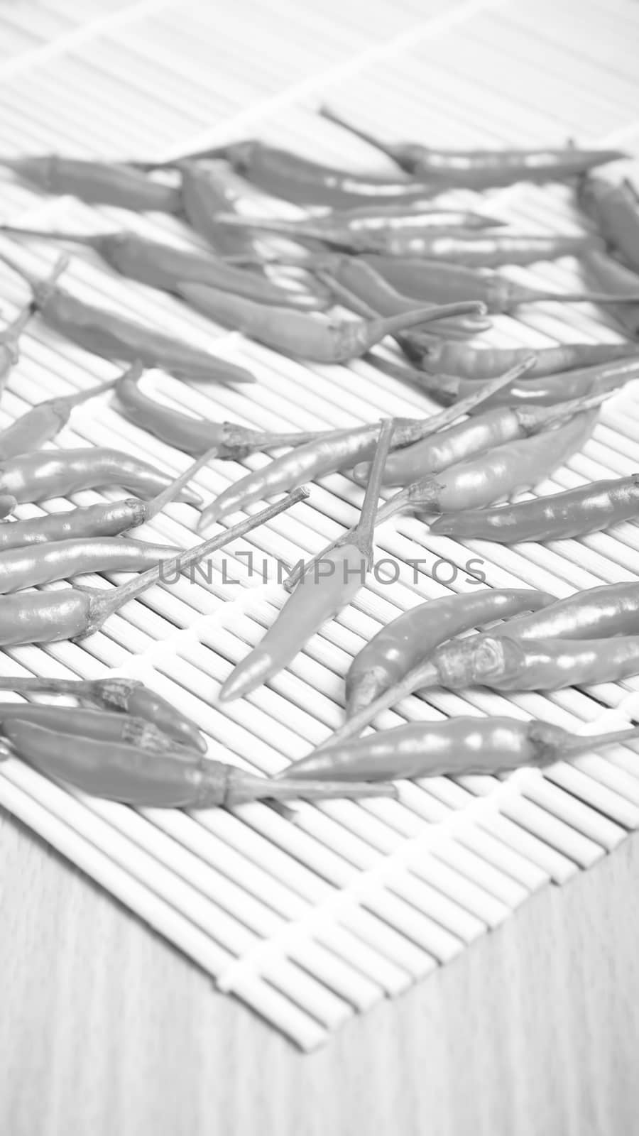 red chili peppers on wood table background black and white tone color style