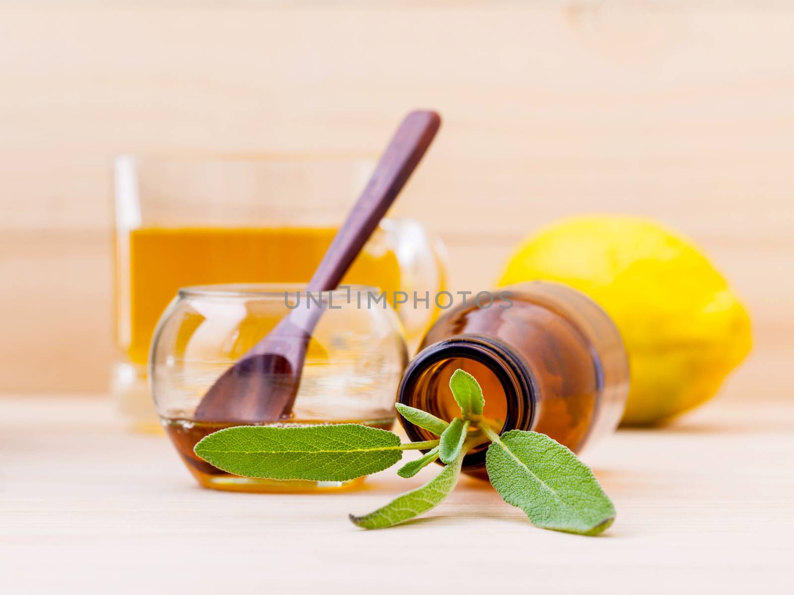 Cup of herbal tea with  fresh sage ,honey and lemon on wooden ba by kerdkanno