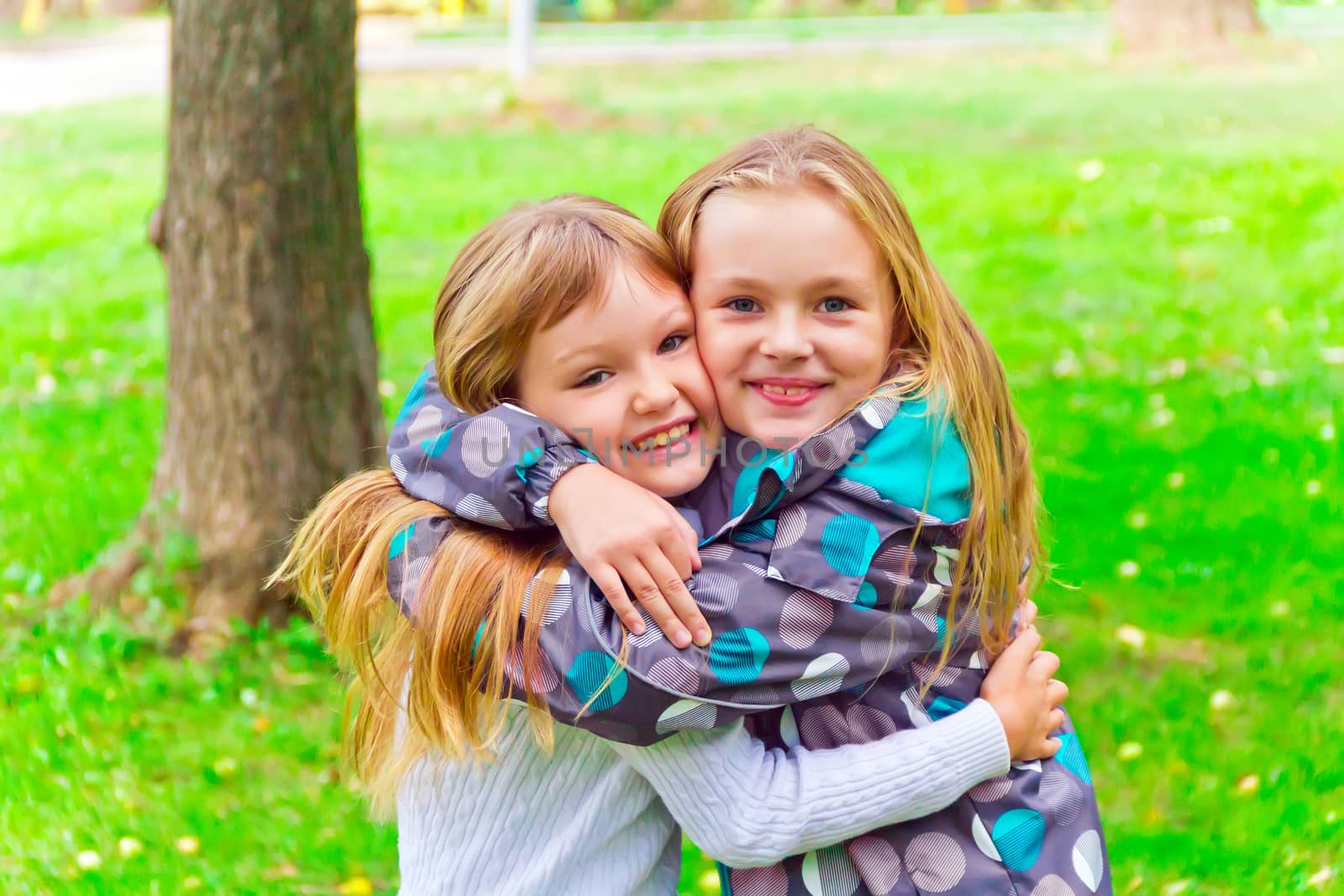 Photo of two embracing girls in summer