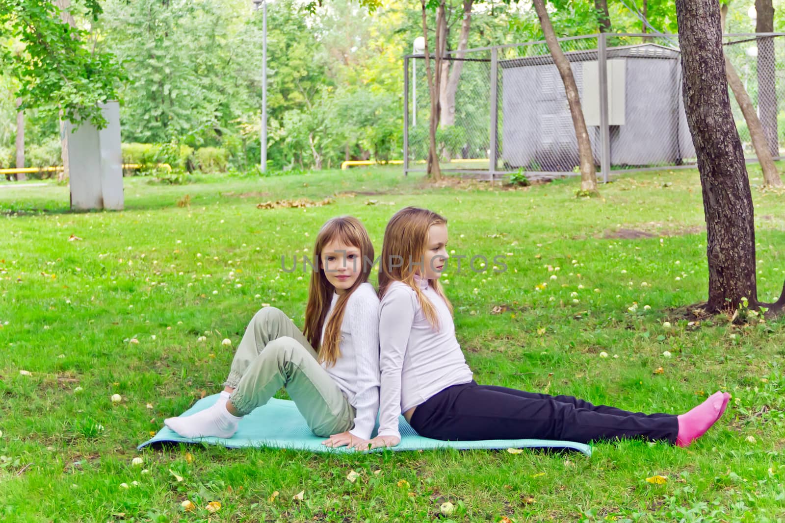 Photo of two girls sitting on grass in summer