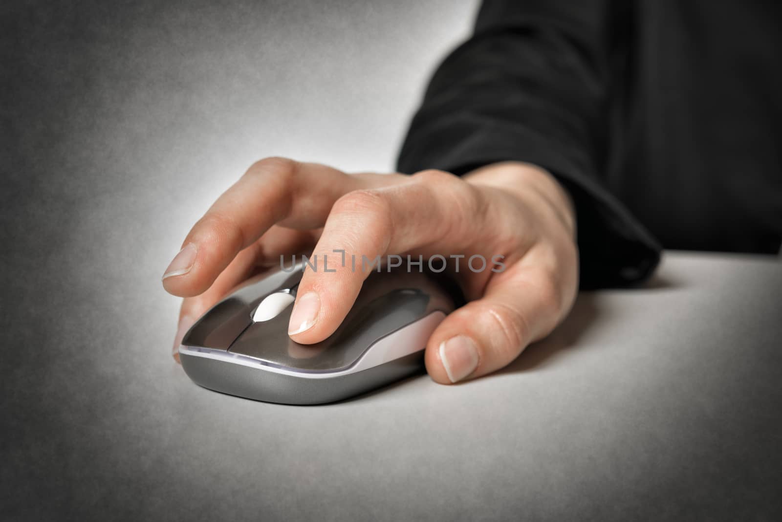 Closeup of a female hand holding a computer mouse operated