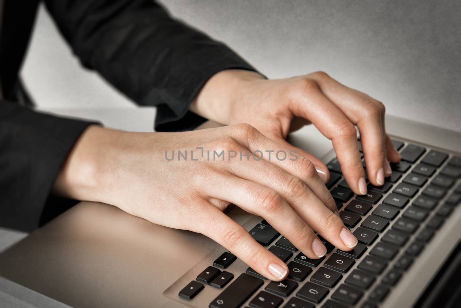 Closeup of hands of a business woman typing on a laptop