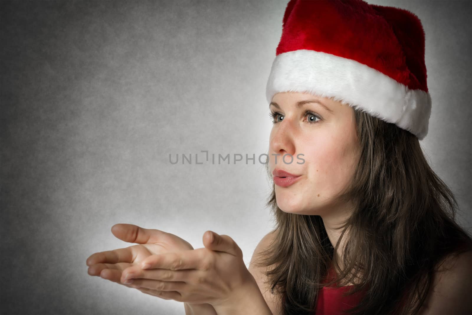 Portrait of a smiling kissing woman wearing Santa Claus costume