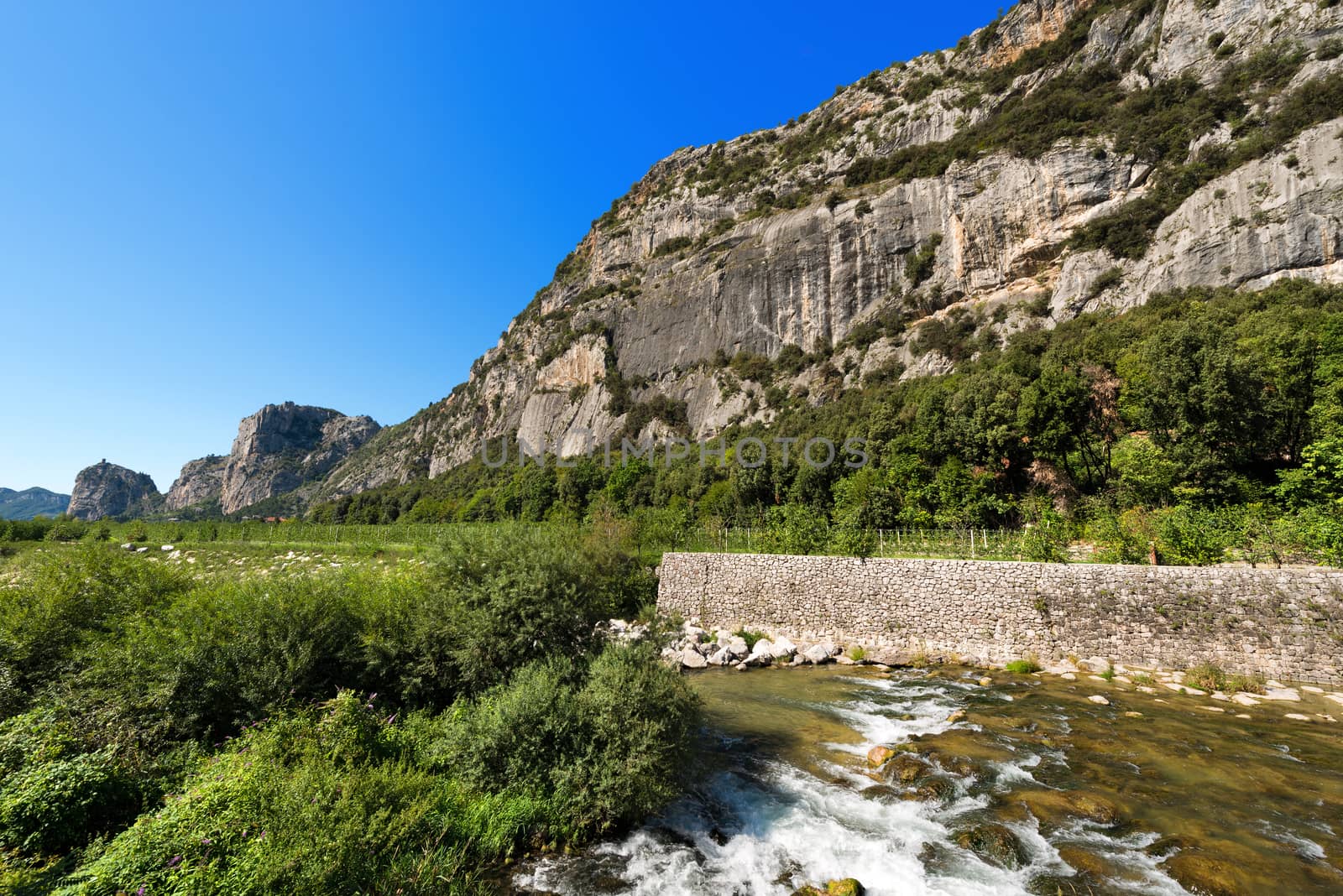 Rock walls with castle in Arco of Trento and Sarca river near the Garda Lake in Trentino Alto Adige, Italy, Europe