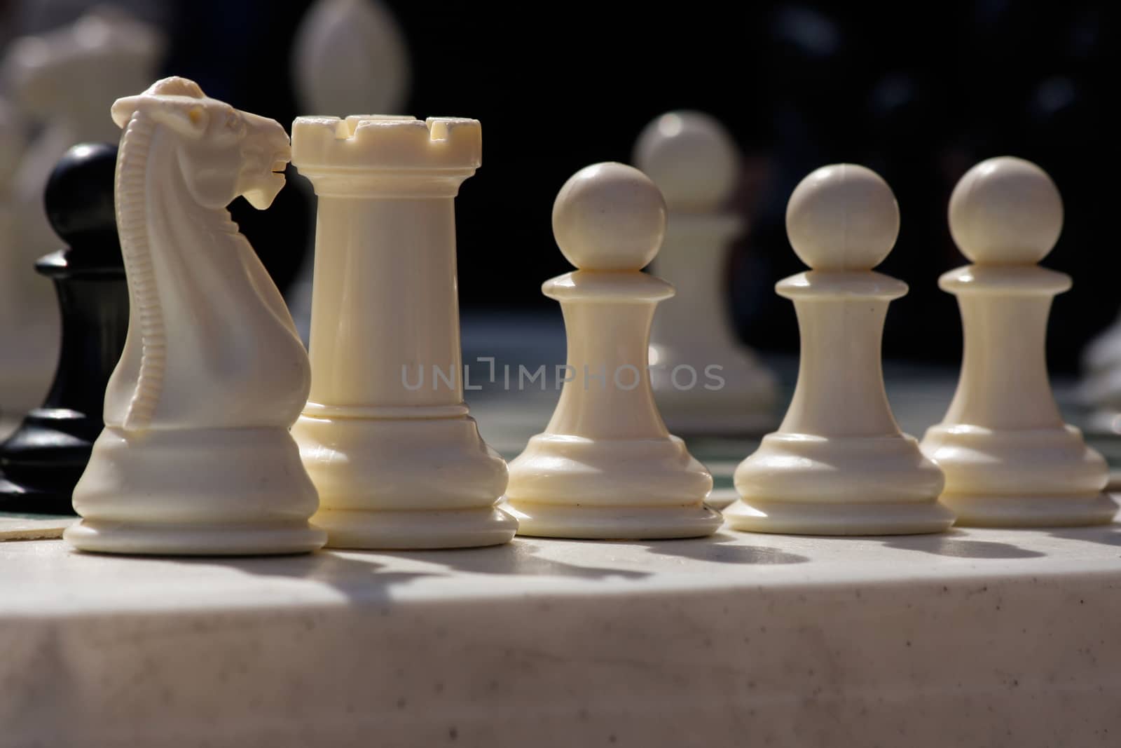 white chess pieces stand ready for battle