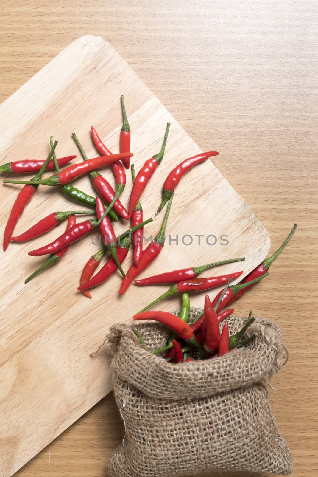 red chili peppers on cutting board over wood table background