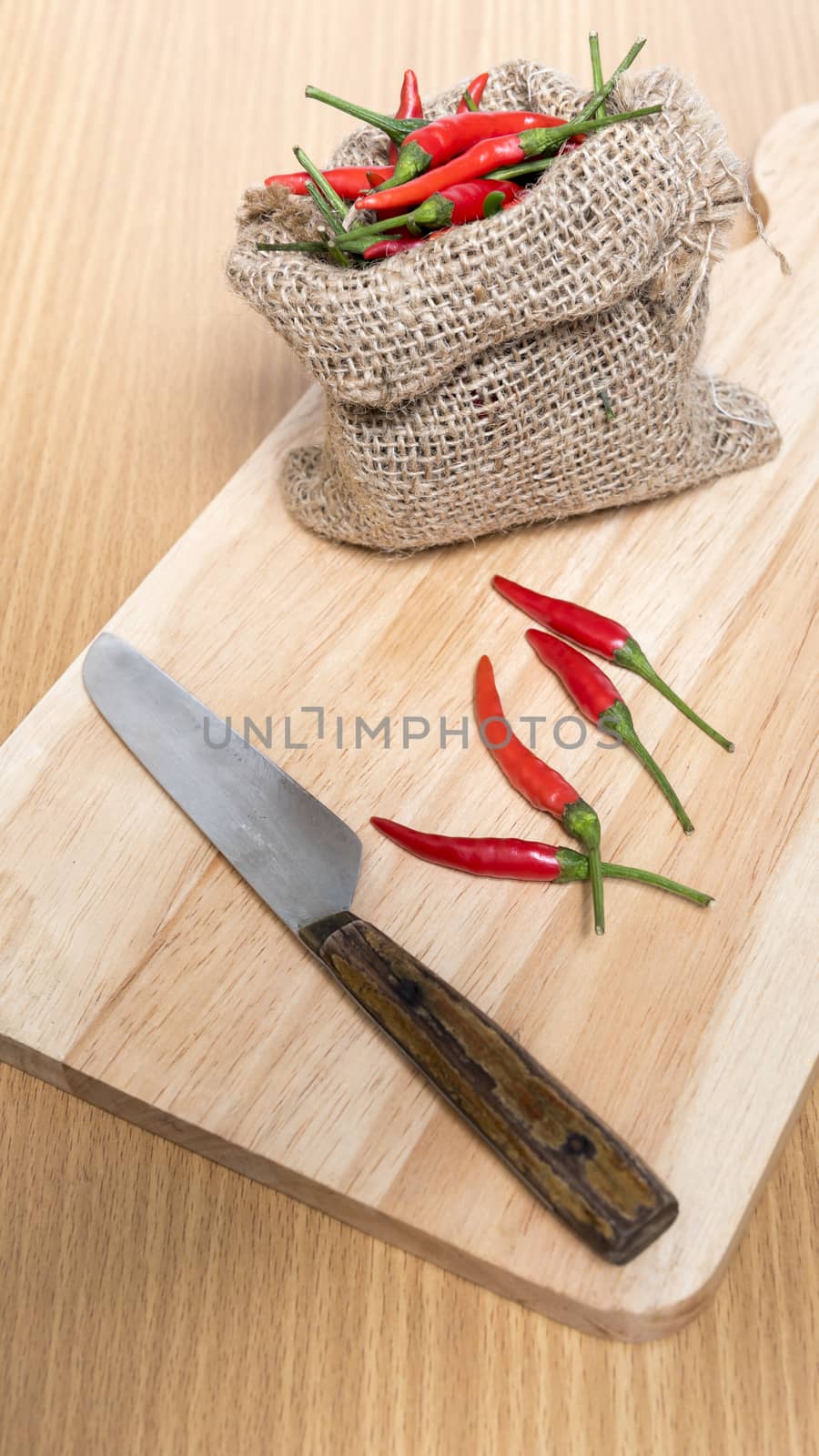 red chili peppers on cutting board over wood table background