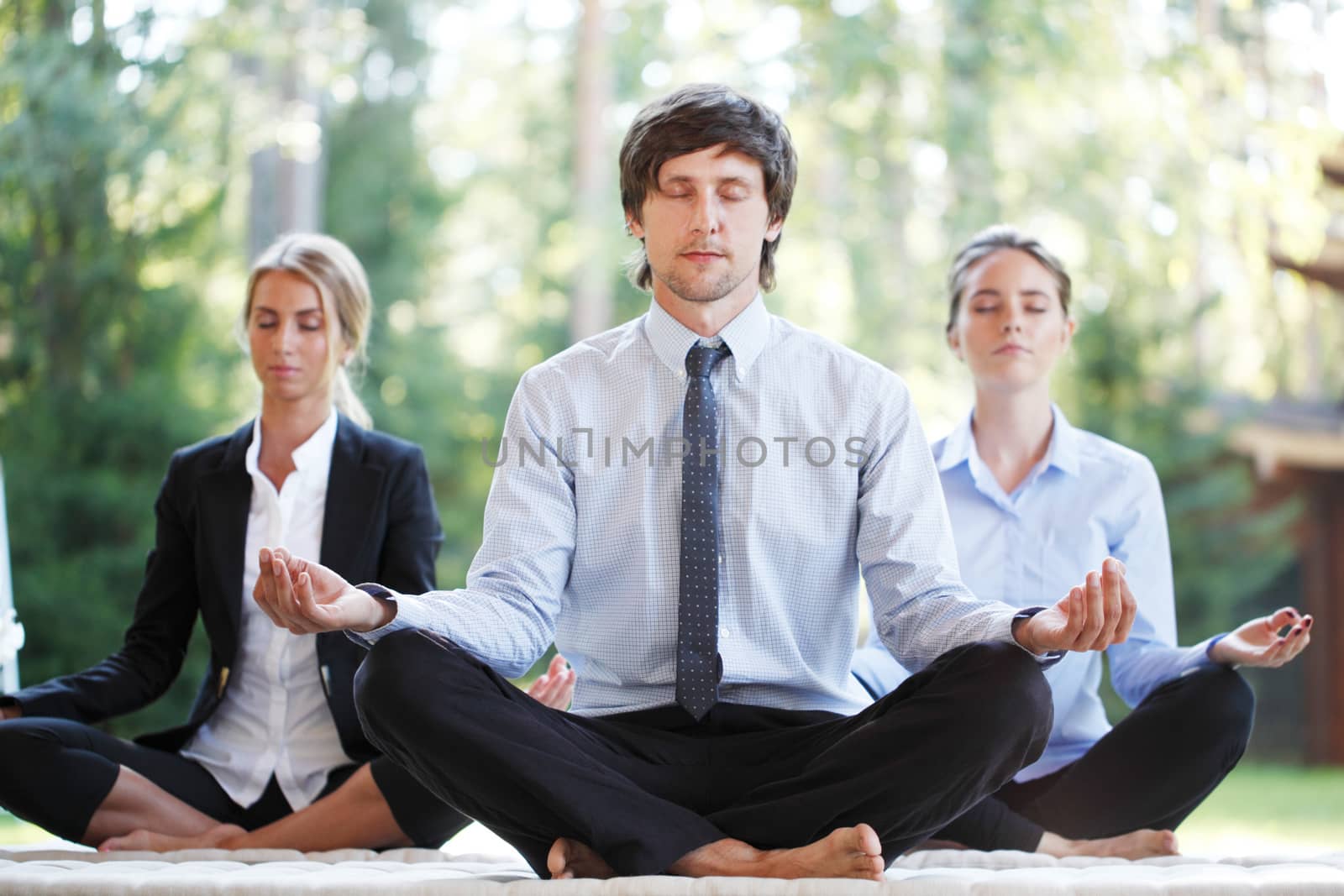 business people doing yoga at the park