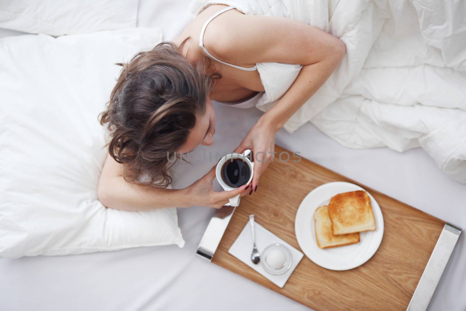 young woman in bed eating breakfast