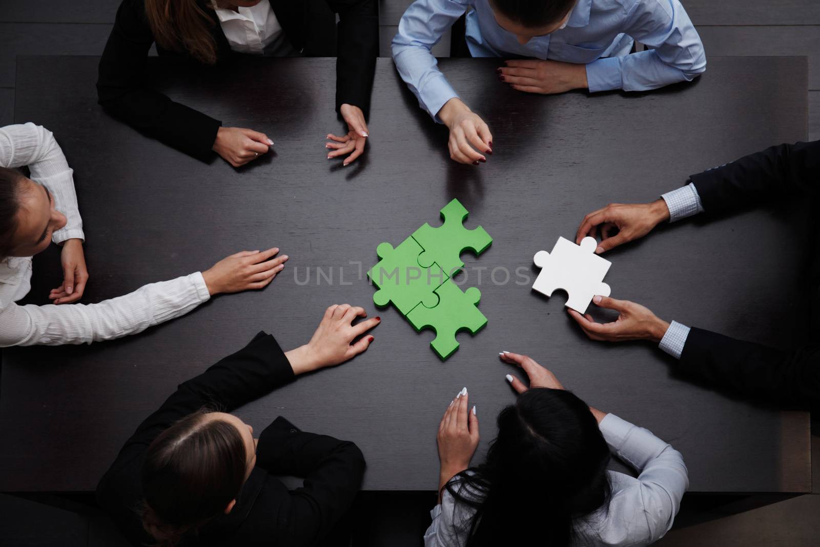 business team solving puzzle together