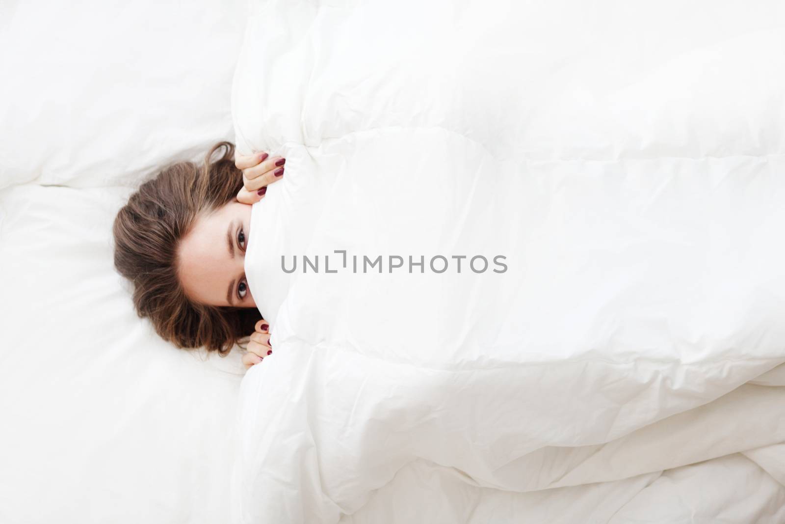 young woman in bed under the blanket