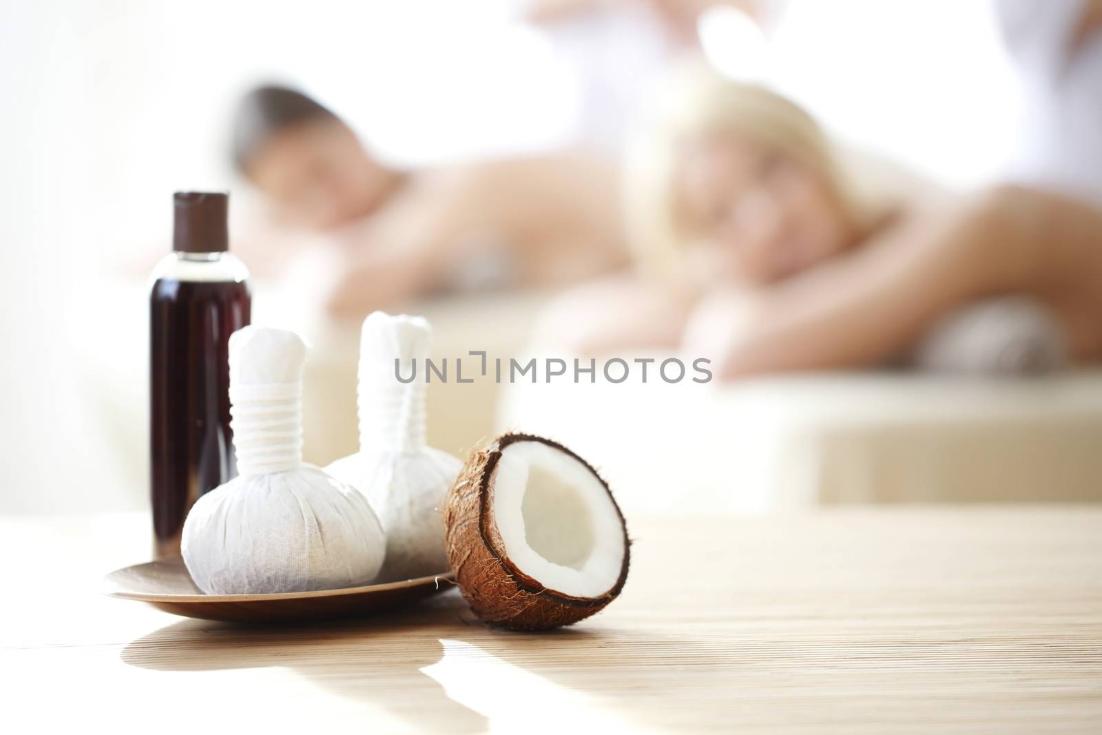 Spa massage tools and women getting massage on background