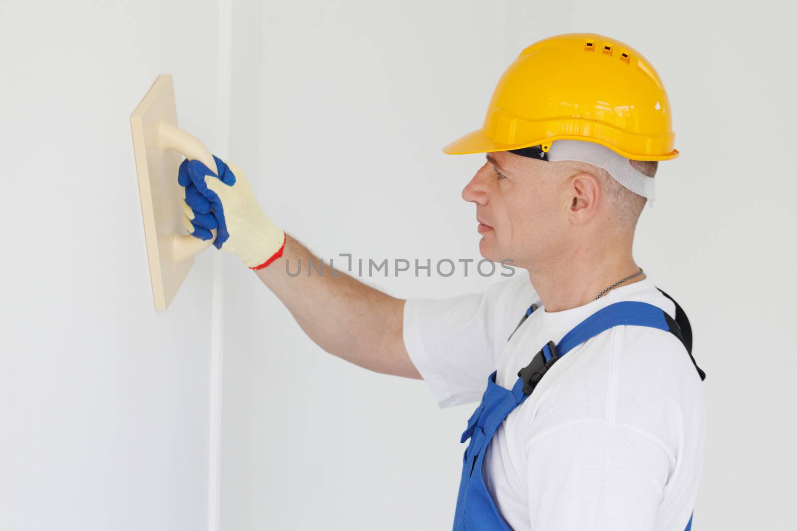 portrait of workman polishing wall