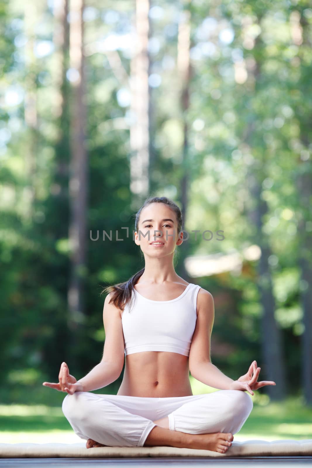 beautiful young woman doing yoga at park