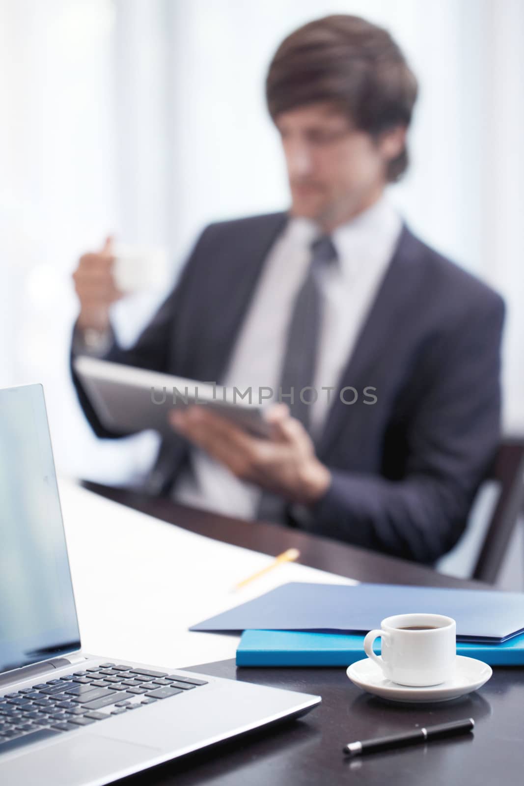 businessman with tablet at work by ALotOfPeople