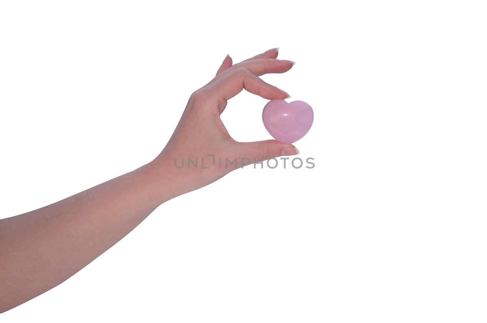 Hand holding Rose Quartz heart on white background