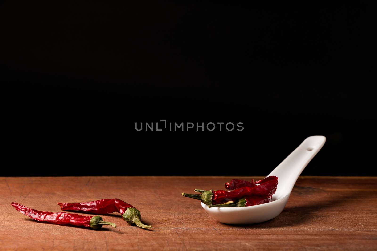 Chili (Capsicum)  threads on a white porcelain spoon