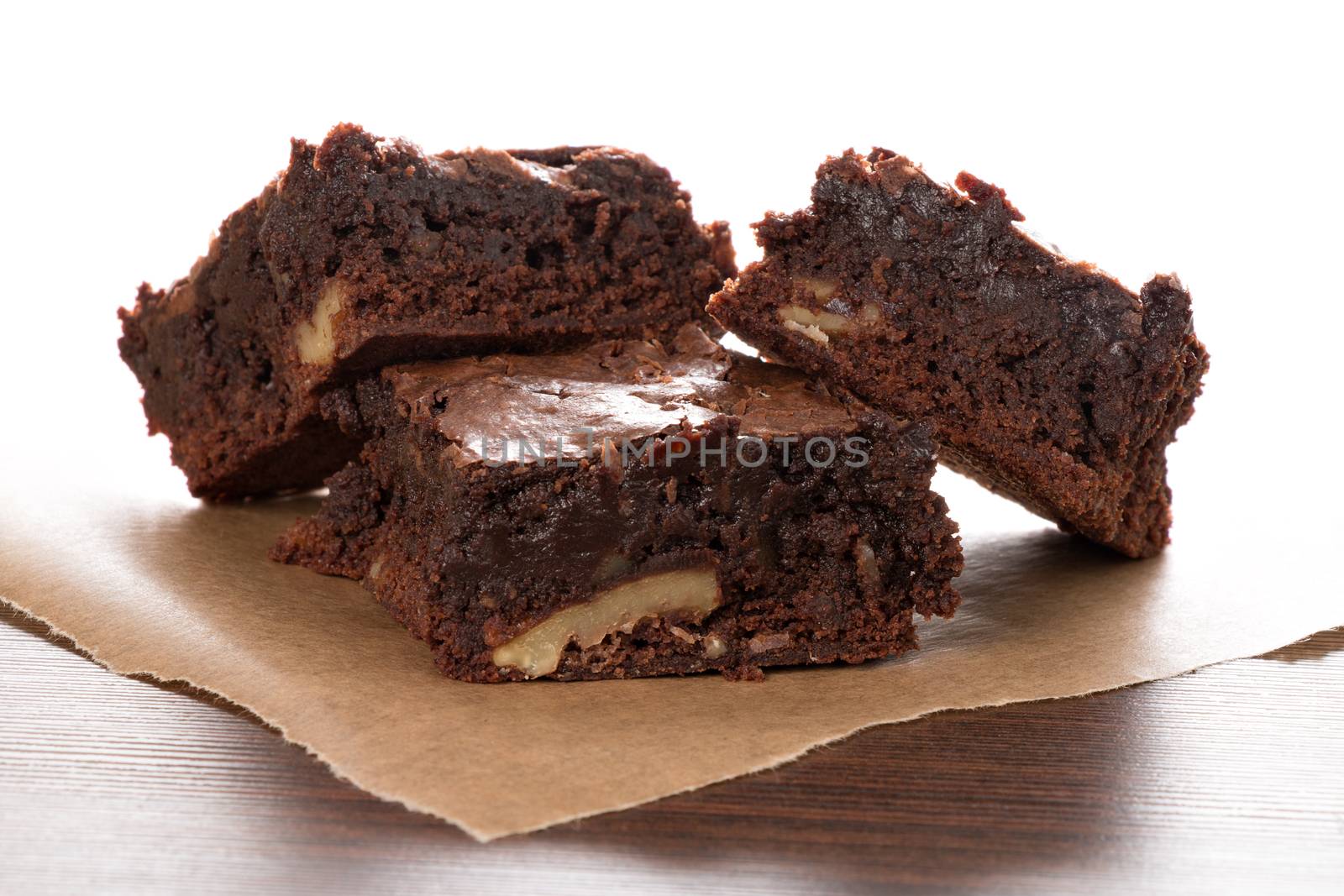 Freshly baked brownies are, served on a piece of baking paper