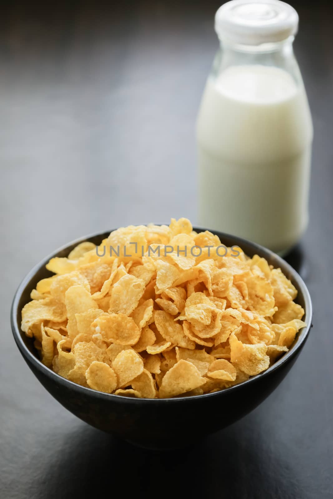 cornflakes with milk on wooden table