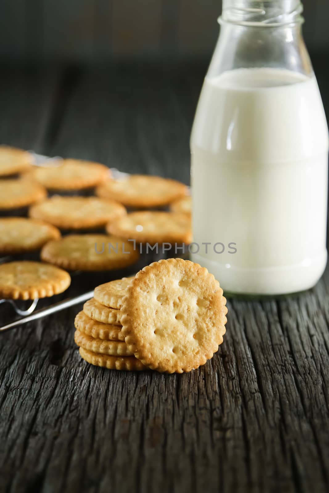Delicious biscuits with milk on a wooden table.