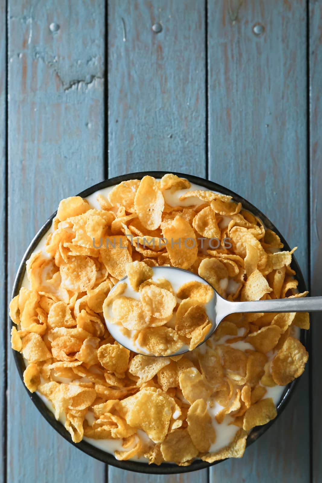 cornflakes with milk on wooden table