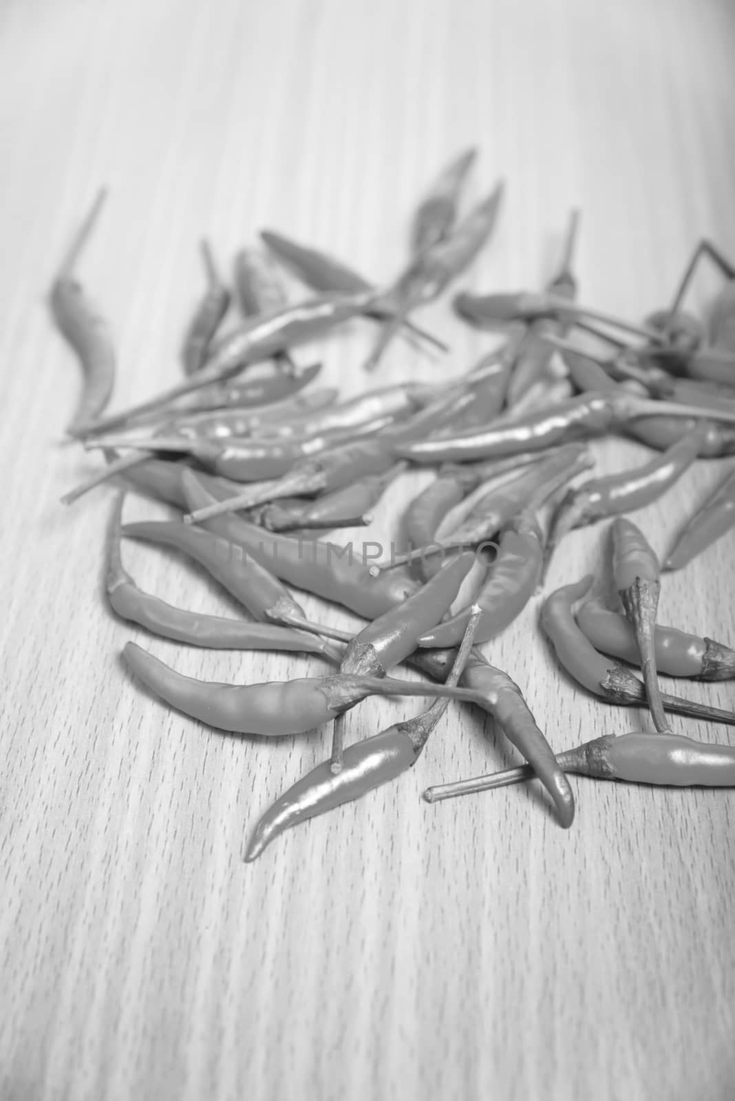 red chili peppers on wood table background black and white tone color style