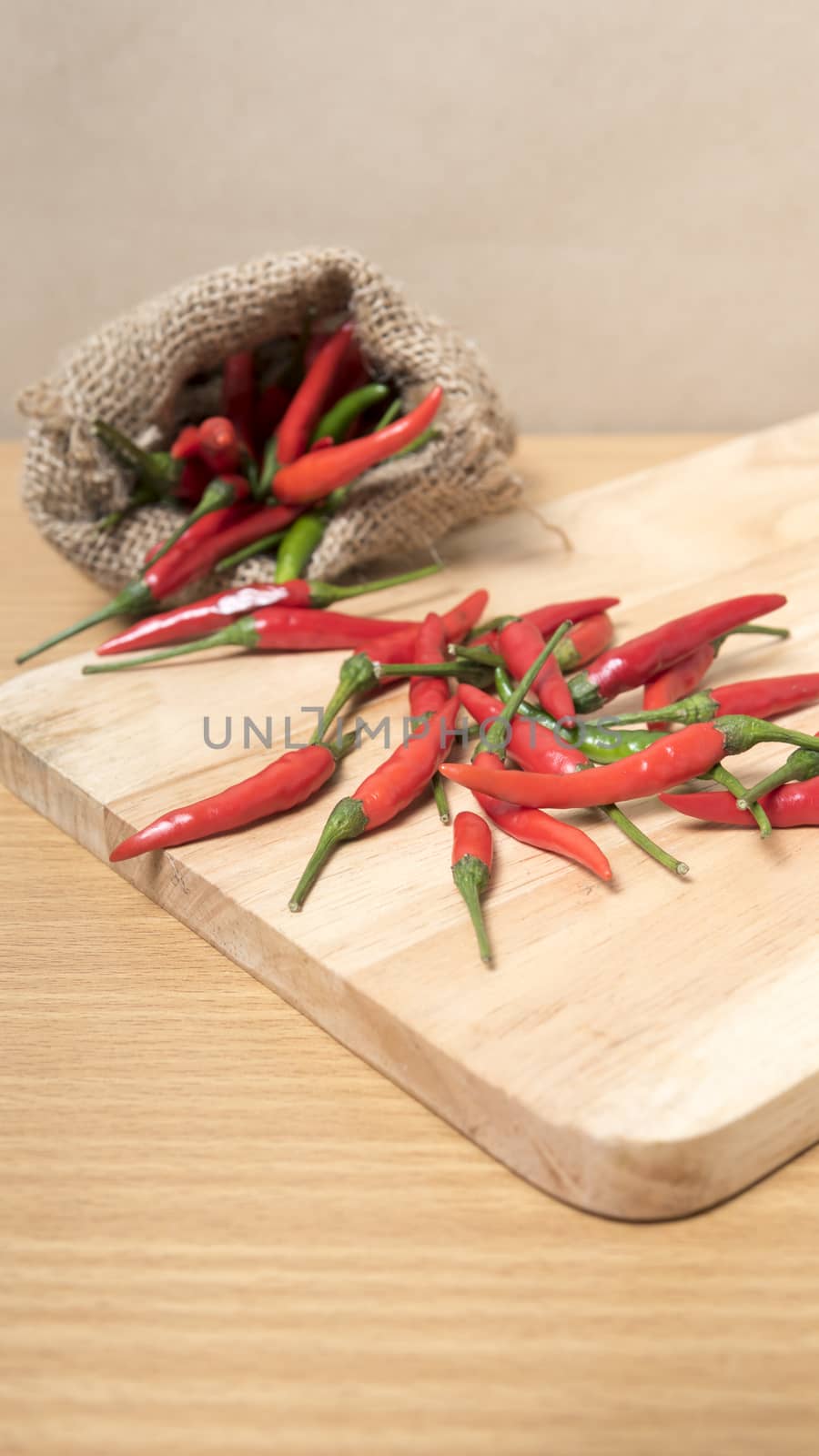 red chili peppers on cutting board over wood table background